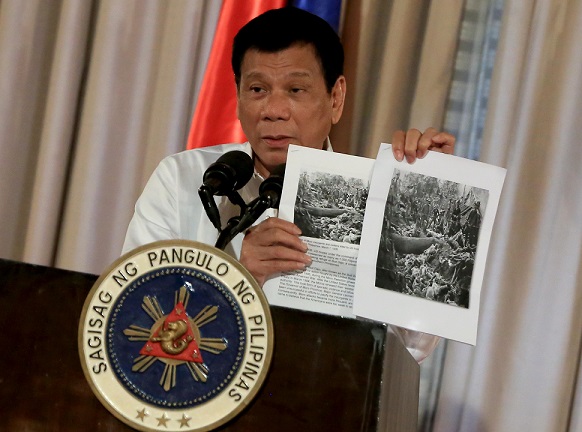 President Rodrigo Duterte shows images of the Bud Dajo massacre during his speech at the 2016 Metrobank Foundation's Outstanding Filipinos awarding ceremony in Malacañan's Rizal Hall on September 12. REY BANIQUET/PPD